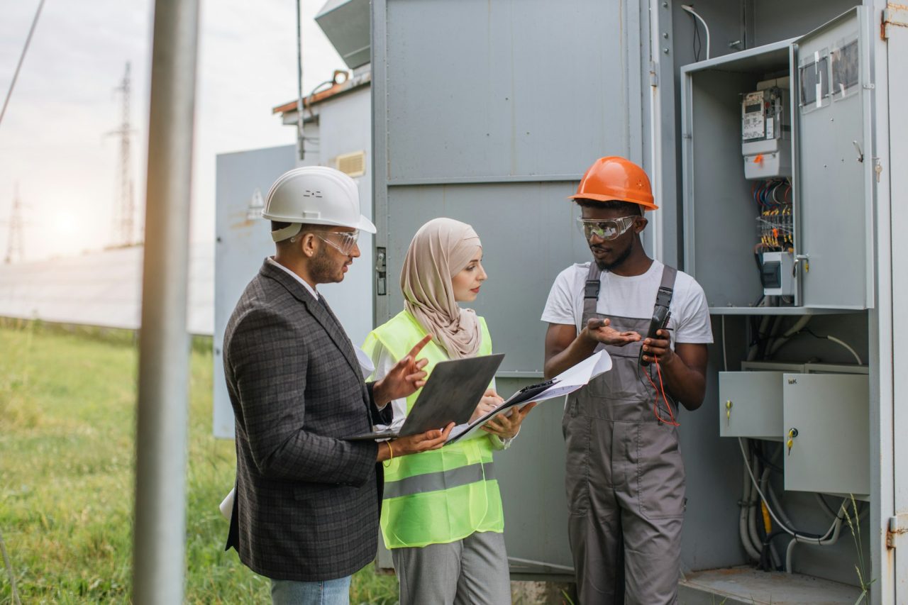 Multiracial people examining solar panels on station.jpg